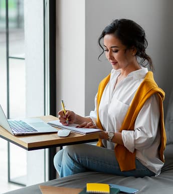 Student writing at a desk